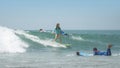 Young woman on surfboard sliding on the waves on a clear day