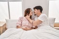 Mand and woman couple kissing and hugging each other sitting on bed at bedroom Royalty Free Stock Photo