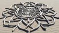 A mandala pattern composed of driftwood is arranged on a sandy surface Royalty Free Stock Photo