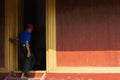 Mandalay, Myanmar - April 2019: Burmese man entering Royal Palace doorway Royalty Free Stock Photo