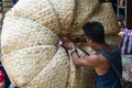 Mandalay, Myanmar - April 2019: Burmese man packing baskets on the street market