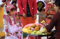 MANDALAY, MYANMAR - DECEMBER 18. 2015: Cute Burmese girl choosing fruits during ceremony at Maha Muni Pagoda