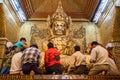 MANDALAY, MYANMAR - DECEMBER 4, 2016: Buddhist devotees put golden leaves on Buddha in Mahamuni Buddha Temple in Mandalay, Myanm