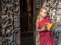 MANDALAY,MYANMAR-FEB 18 : Young Novice monks standing and reading at Shwenandaw Monastery is built in the traditional Burmese arc