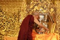 MANDALAY, MYANMAR - FEBRUARY 3,2018 : The senior monk being of face wash to Mahamuni Buddha image at Mahamuni temple is Buddha and