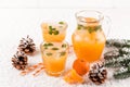 Mandarin cocktail with ice and mint in beautiful glasses and jug, fresh ripe citrus on white wooden background. Sweet orange juice Royalty Free Stock Photo