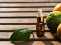 Mandarin essential oil citrus in a glass bottle on wooden background, next to fresh tangerines. Next to the oil is a leaf of Royalty Free Stock Photo