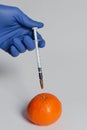 Mandarin injected with pesticides needle syringe