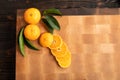 Mandarin with leaves on wooden cutting board