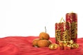 Mandarin oranges, gold ingots and Traditional Chinese golden firecrackers on red cloth. Royalty Free Stock Photo