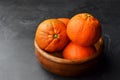 Mandarin organic fruits in wooden bowl on black background