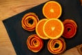 Mandarin is served on a dark stone with a decor of a peel citrus. A half tangerine and peel of spiral on a plate.