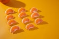 Mandarin slices lie in rows on an orange background. Concept photo.Advertising photo