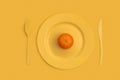 Mandarin on top on a yellow plate, knife and fork. On a yellow background. View from above. Royalty Free Stock Photo