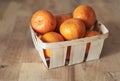 Mandarines in a basket on wooden surface