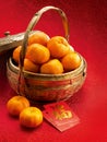 Mandarins in a basket and red packets in red clot Royalty Free Stock Photo