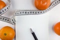 Mandarins, notepad, centimeter tape on a white background dieting Royalty Free Stock Photo