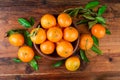 Mandarins tangerines in a ceramic bowl on wooden table. Top view