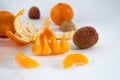 Mandarins on a white background with lobule, peel, citron and litchi. Side view, close. Citrus reticulata. Litchi chinensis