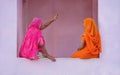 Two Indian women wearing colorful saris.