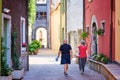 Mandello del Lario, Italy - July 26, 2020. Senior couple traveling together, walking in italian village in summer