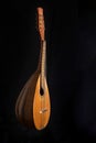 Mandolin is placed vertically on a black background