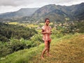 Mandraka, Madagascar - April 24, 2019: Unknown Malagasy girl standing on grass ground bare feet, overcast day, trees and shrubs