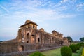 Mandu India, afghan ruins of islam kingdom, palace interior, mosque monument and muslim tomb. Sunshine from door in dark corridor.