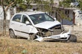 White car severely damaged from accident parked on street in India