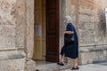 Manduria, Italy - August, 25, 2020. An old lady in face medical mask is entering the Mother Church of Manduria, Puglia