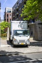 Maneuverable white compact cab over small light duty rig semi truck with long box trailer standing on the urban city street Royalty Free Stock Photo