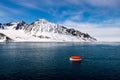 Maneuvering orange lifeboat in water in Arctic waters, Svalbard. Abandon ship drill. Lifeboat training. Man over board drill Royalty Free Stock Photo