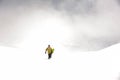 Manful snowboarder walking down the hill in the mountain resort