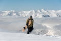 Manful snowboarder walking with the snowboard in the mountain re