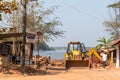 A bulldozer demolishing old structures by the riverside in the village of Boloor near