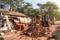 A bulldozer demolishing old structures in the village of Boloor near Mangaluru