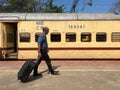 A passenger walking with his luggage to board a train at Mangaluru railway station