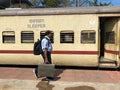 A passenger walking with his luggage to board a train at Mangaluru railway station