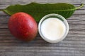 Mango body butter in a glass bowl and fresh ripe organic mango fruit on old wooden background.Spa,natural oils,organic cosmetic o Royalty Free Stock Photo