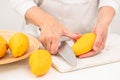 Woman cutting mango on white cutting board, preparing fruit salad Royalty Free Stock Photo