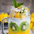 Mango, coconut and chia seeds pudding in glass jar