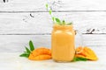 Mango coconut smoothie in a jar against rustic white wood Royalty Free Stock Photo