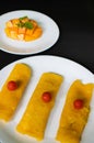 Mango crÃÂªpe an Indian dessert dish decorated with raw mango in the background on black surface Royalty Free Stock Photo