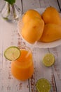 Mango drink close-up with lime slice on white vintage wooden table Royalty Free Stock Photo