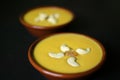 Mango firni a traditional dessert from India garnished with cashew nuts on black surface