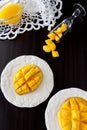 Mango fruit cubes and mango juice puree on dark wooden background