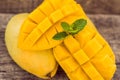 Mango fruit and mango cubes on the wooden table Royalty Free Stock Photo