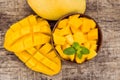 Mango fruit and mango cubes on the wooden table Royalty Free Stock Photo