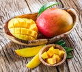 Mango fruit and mango cubes on the wood. Royalty Free Stock Photo