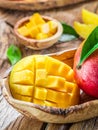Mango fruit and mango cubes on the wood. Royalty Free Stock Photo